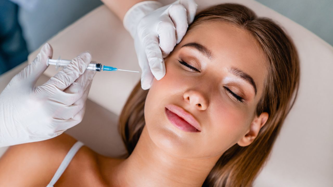 Young woman gets beauty facial injections in salon